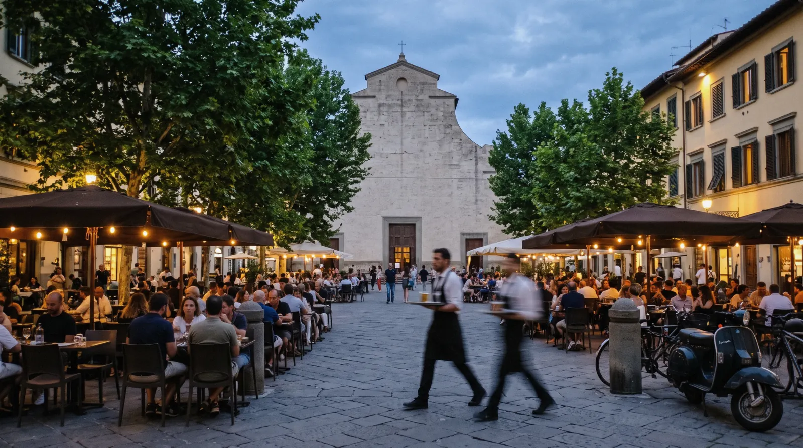 Piazza Santo Spirito at dusk with cafe tables filling, Oltrarno district of Florence