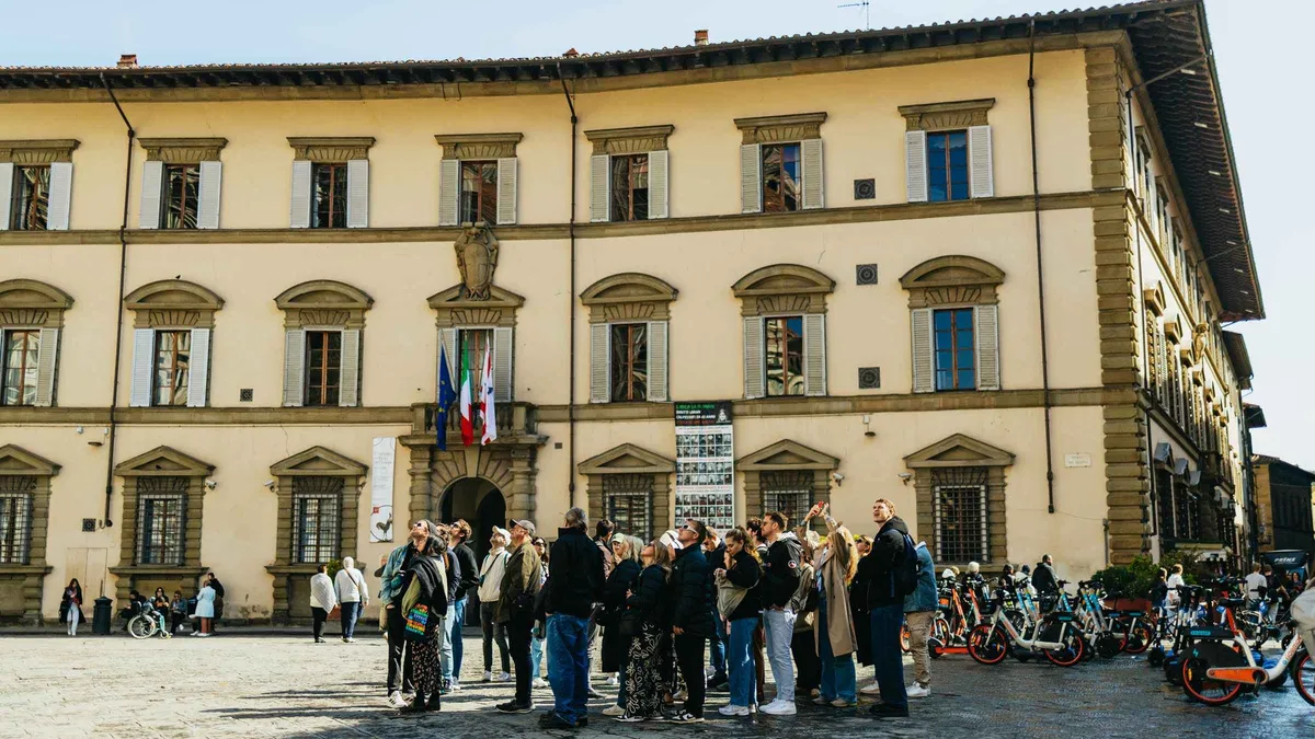 Guide telling Medici stories in front of Brunelleschi's Dome on a Florence walking tour in Italy