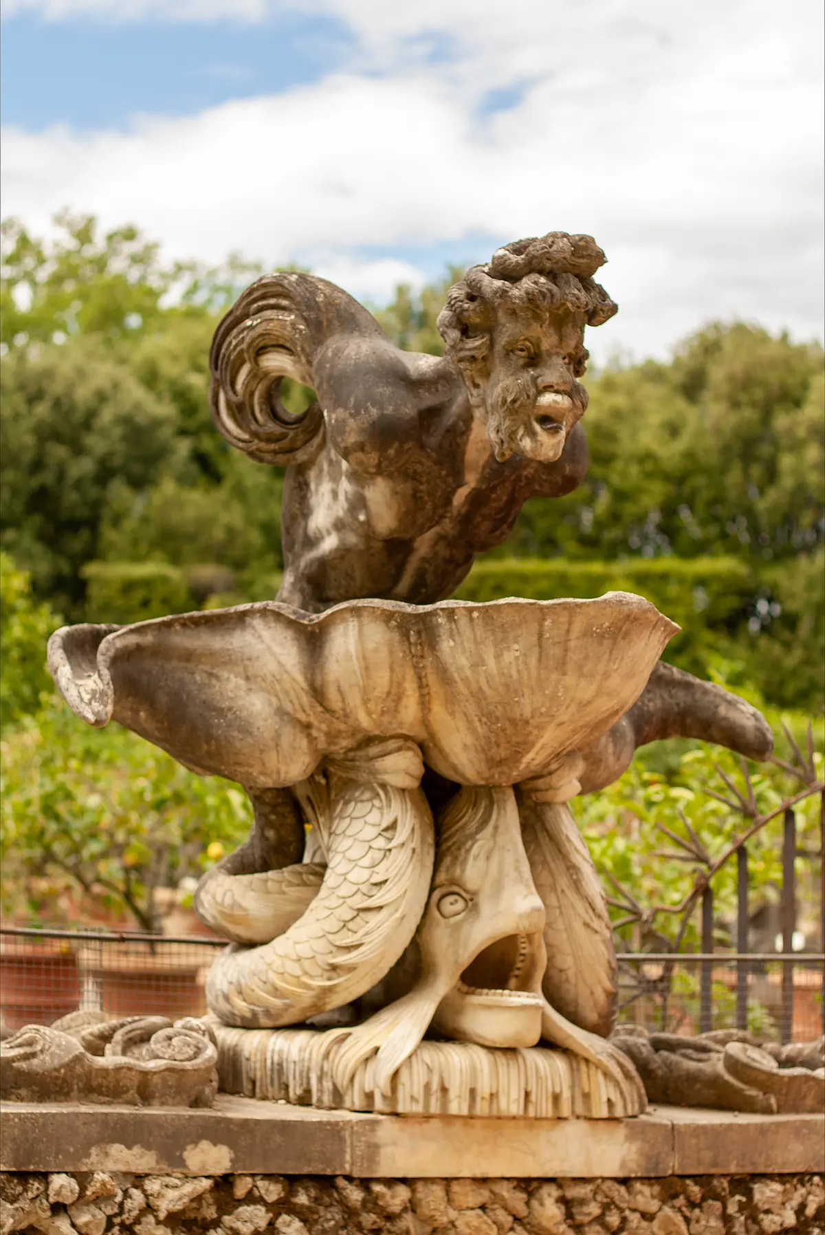 A weathered marble fountain among the hedges and lemon trees of the Boboli Gardens
