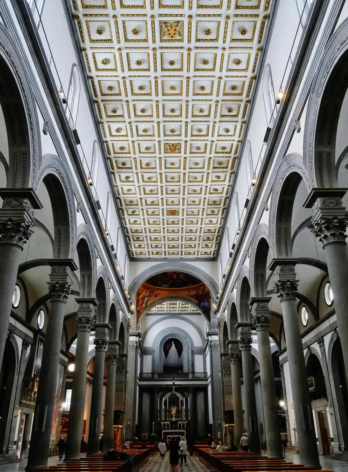 Brunelleschi's grey pietra serena columns and coffered ceiling down the nave of the Basilica of San Lorenzo in Florence