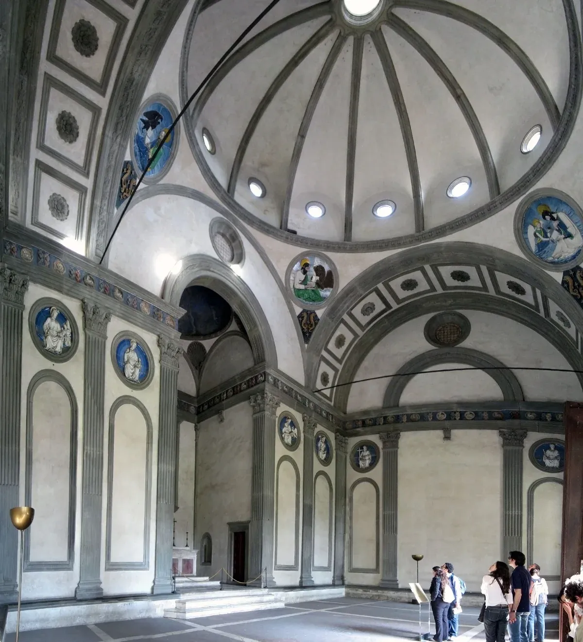 Interior of the Pazzi Chapel in the first cloister of Santa Croce, Florence, with grey pietra serena and Luca della Robbia's apostle roundels